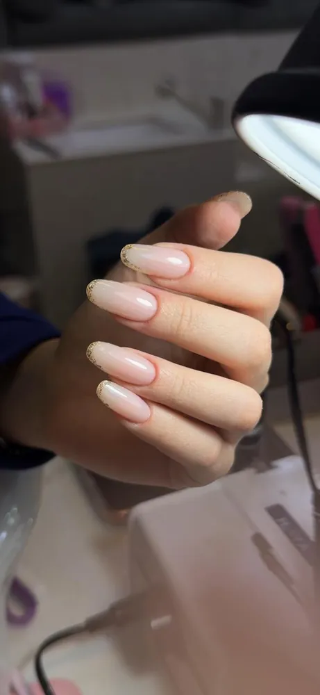 Nude French nails with gold glitter tips